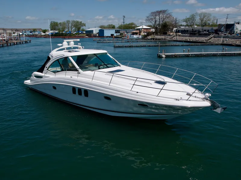 Slide: The Image of 2009 Sea Ray 48 Sundancer yacht cruising in a marina under clear skies. - 2