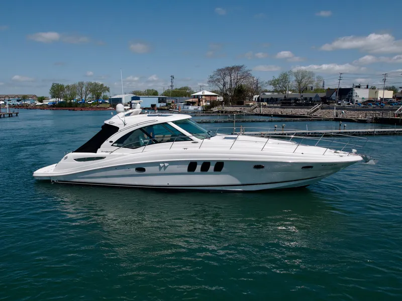 Slide: The Image of 2009 Sea Ray 48 Sundancer yacht on calm water, dockside view. - 3