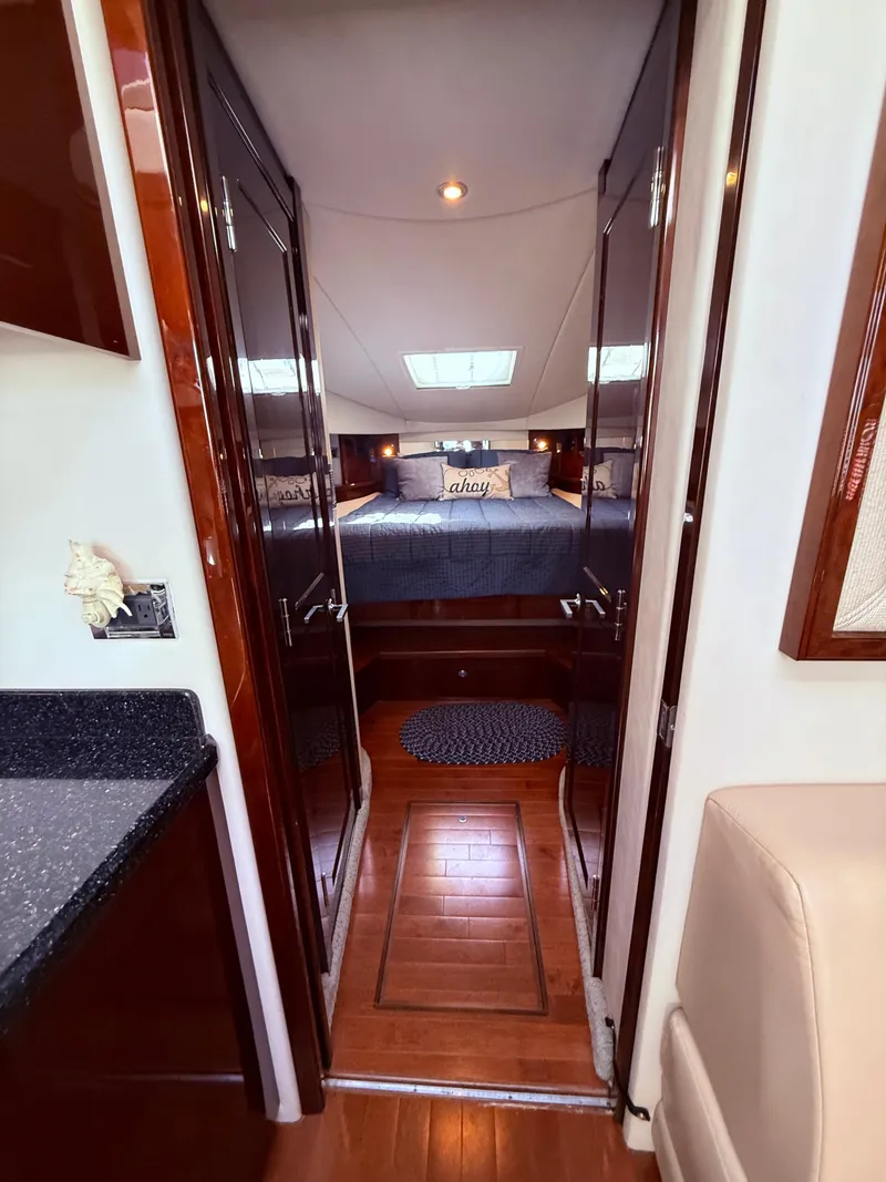 Slide: The Image of Interior of 2009 Sea Ray 48 Sundancer yacht, featuring a cozy bedroom with elegant wood finishes. - 32