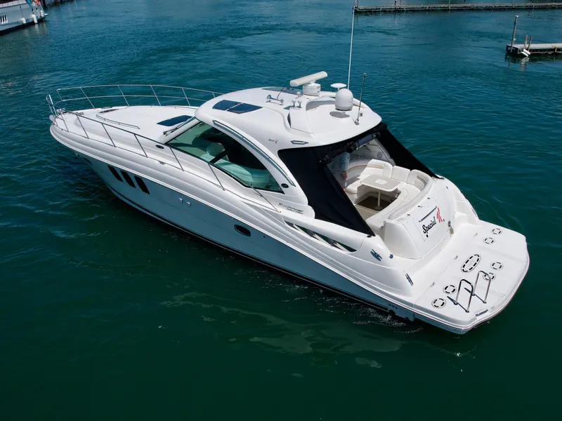 Slide: The Image of 2009 Sea Ray 48 Sundancer yacht on clear blue water, showcasing sleek design and spacious deck. - 4