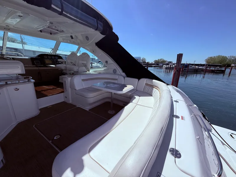 Slide: The Image of 2009 Sea Ray 48 Sundancer yacht interior with seating, docked by the water. - 6