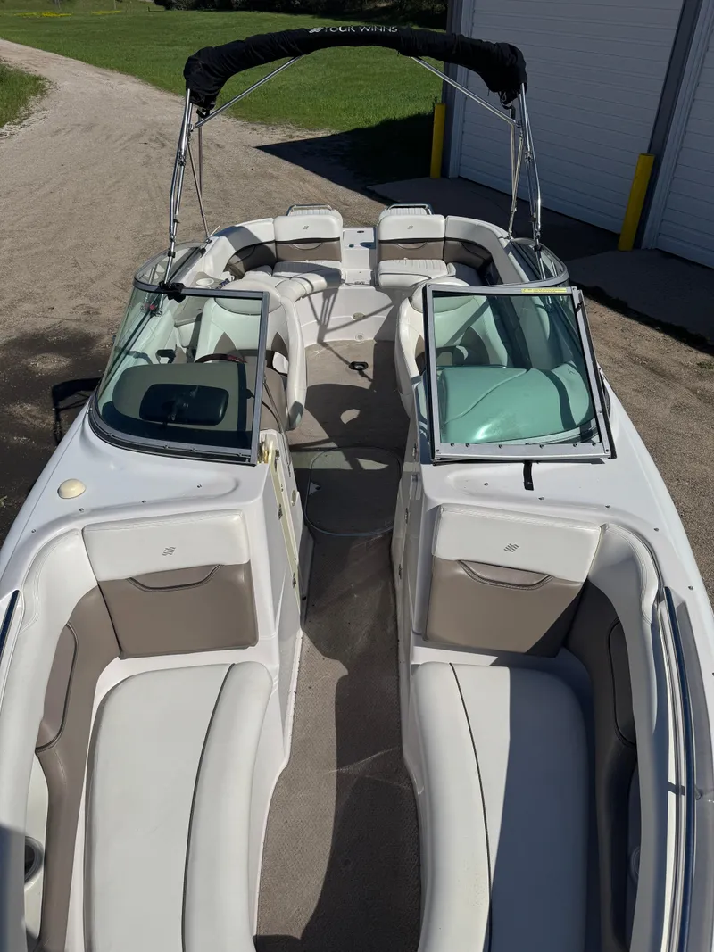 Slide: The Image of 2004 Four Winns 250 Horizon boat with spacious seating and sleek design. - 10