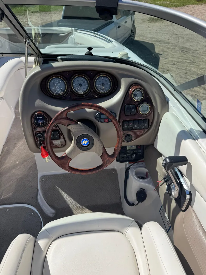 Slide: The Image of 2004 Four Winns 250 Horizon boat dashboard with gauges and steering wheel. - 12