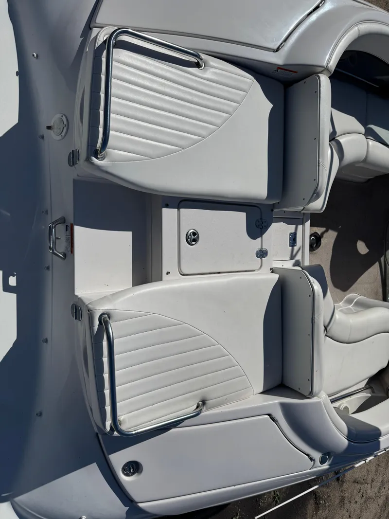 Slide: The Image of 2004 Four Winns 250 Horizon boat interior with white seating and storage compartments. - 14