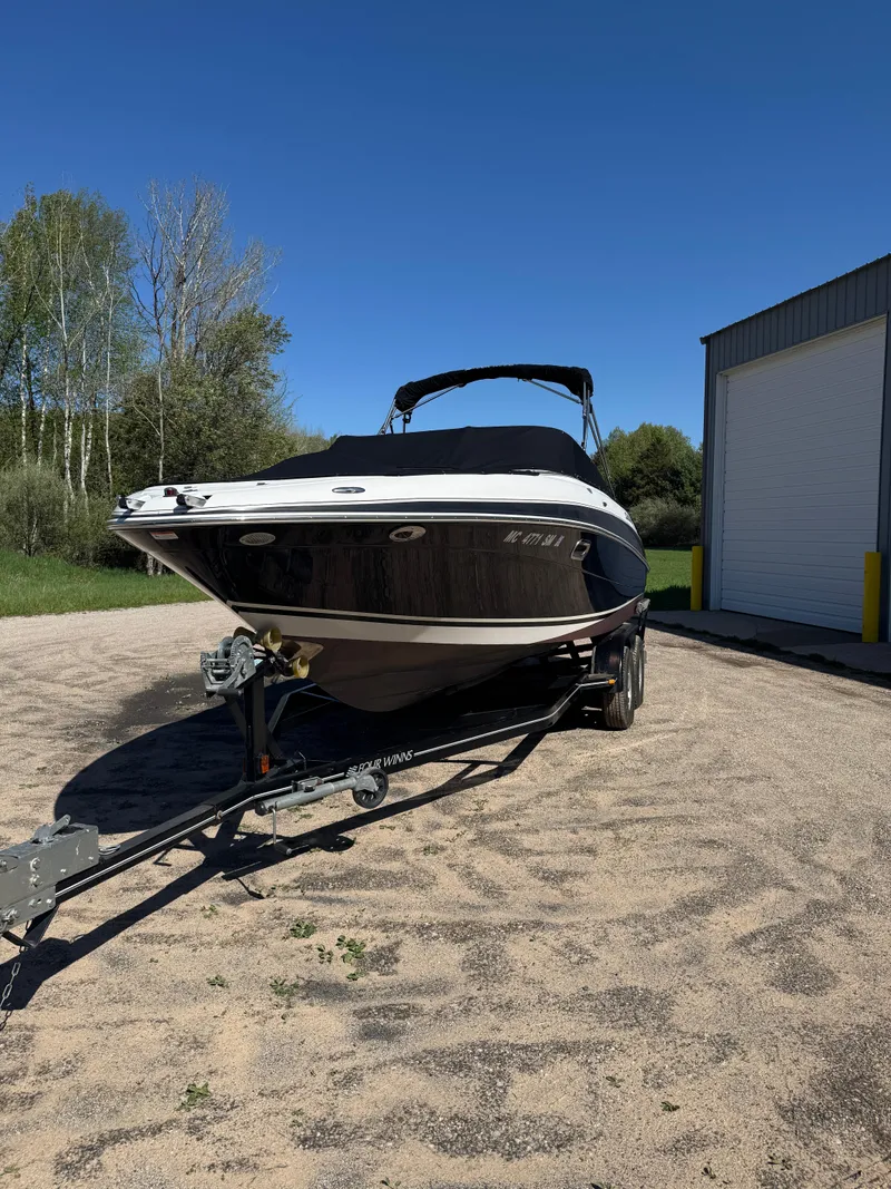Slide: The Image of 2004 Four Winns 250 Horizon boat on trailer, parked outdoors near a building. - 4