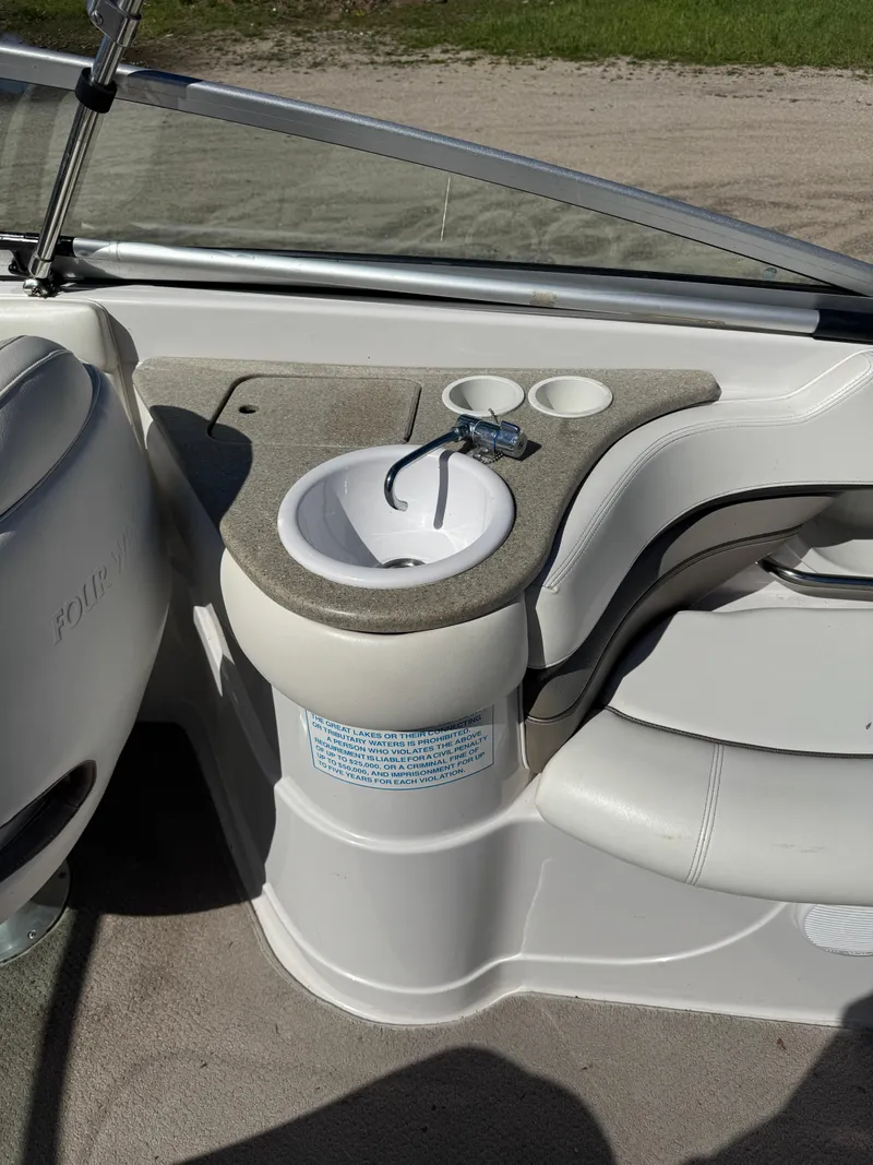 Slide: The Image of 2004 Four Winns 250 Horizon boat interior with sink and cup holders. - 9