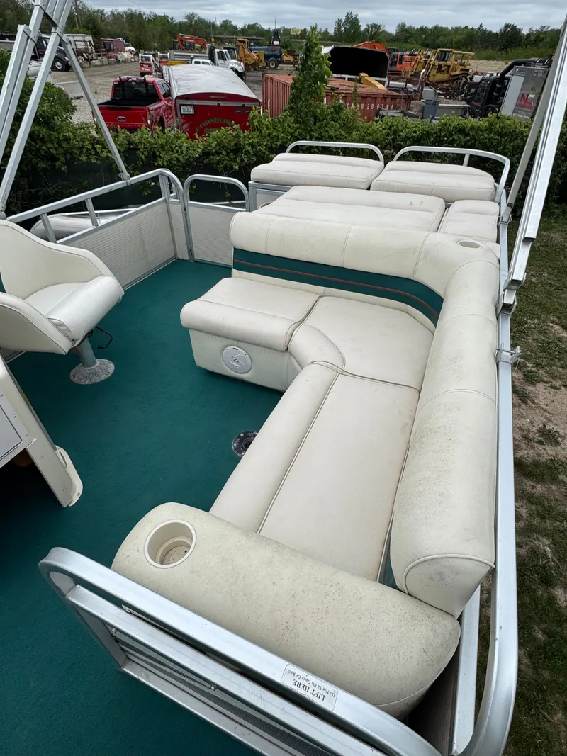 Slide: The Image of 1996 Premier Odyessea boat with white seating and green carpet, parked outdoors. - 10