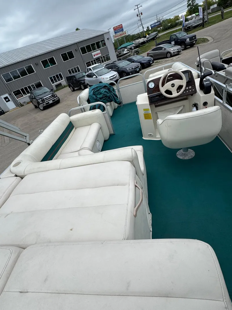 Slide: The Image of 1996 Premier Odyessea boat with white seating and teal carpet, parked near a building. - 14