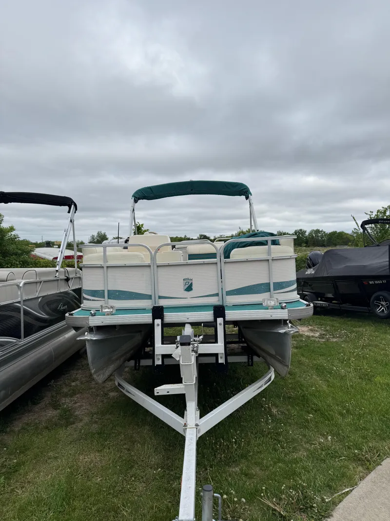Slide: The Image of 1996 Premier Odyessea pontoon boat on trailer, parked on grass under cloudy sky. - 7