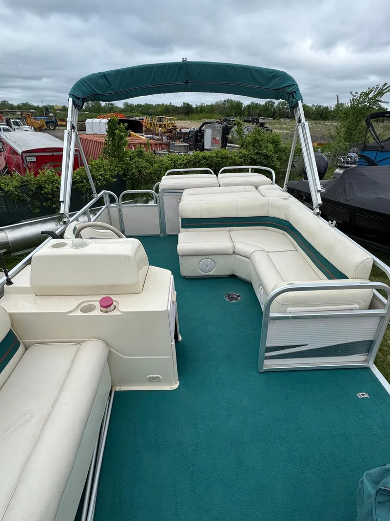 Slide: The Image of 1996 Premier Odyessea pontoon boat with green canopy and seating, parked outdoors. - 9