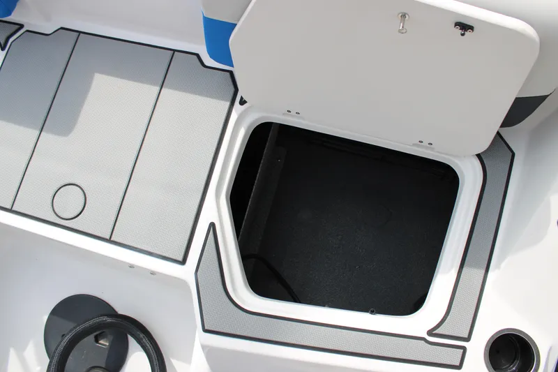 Slide: The Image of 2025 Starcraft SV 16 OB boat storage compartment with open hatch and steering wheel. - 4