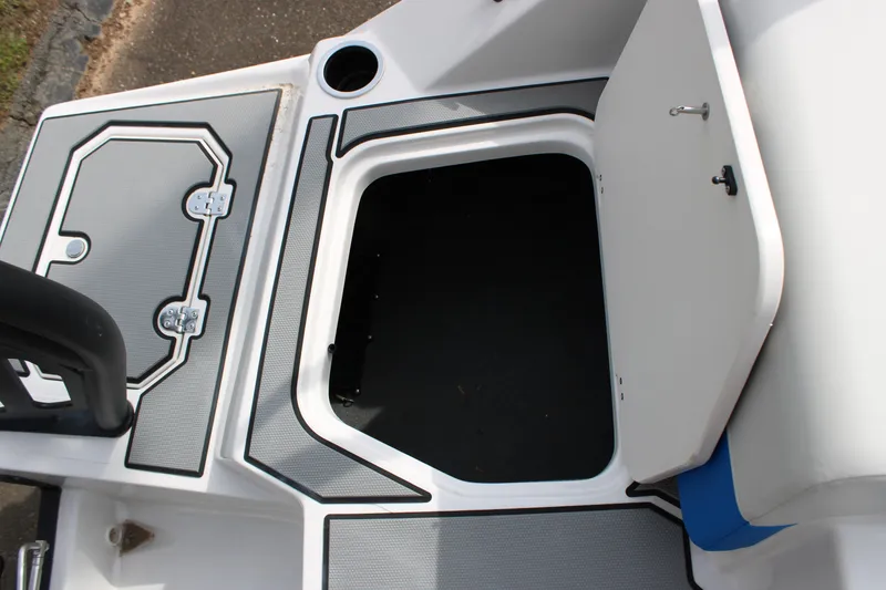 Slide: The Image of 2025 Starcraft SV 16 OB boat storage compartment with open hatch and cup holder. - 5