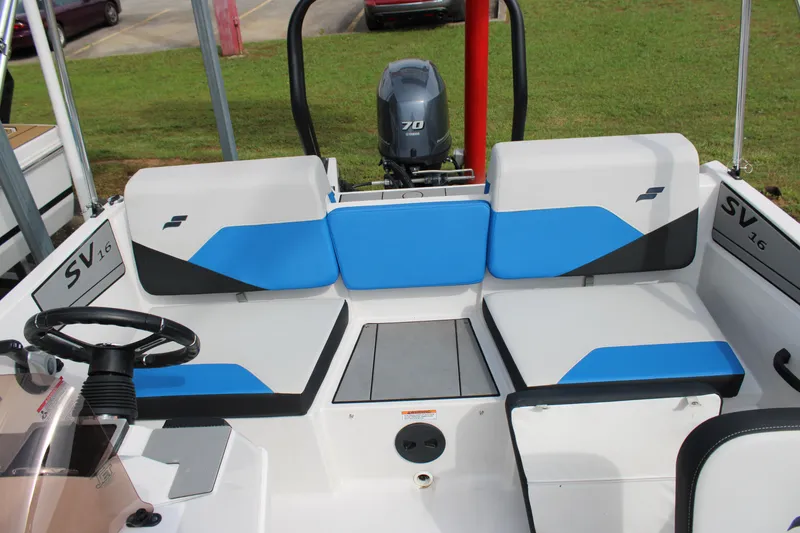 Slide: The Image of 2025 Starcraft SV 16 OB boat interior with blue and gray seating and steering wheel. - 8