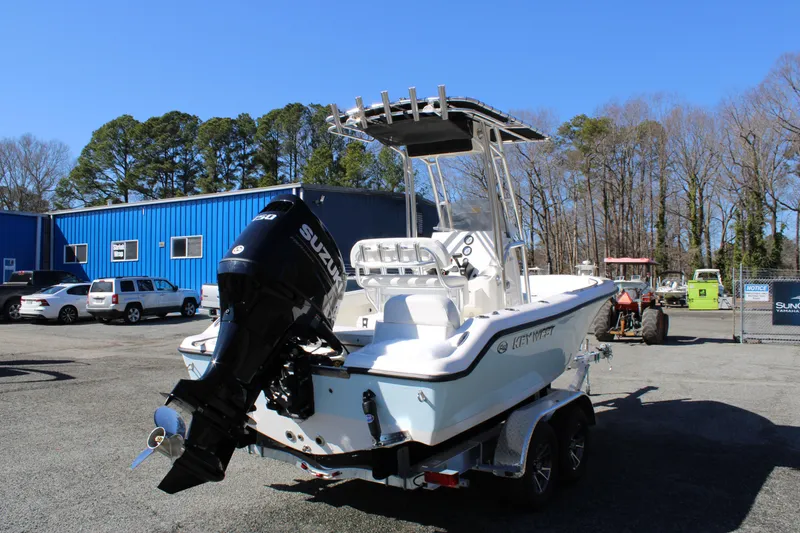 Slide: The Image of 2025 Key West 189 FS boat with Suzuki outboard motor in a parking lot. - 1