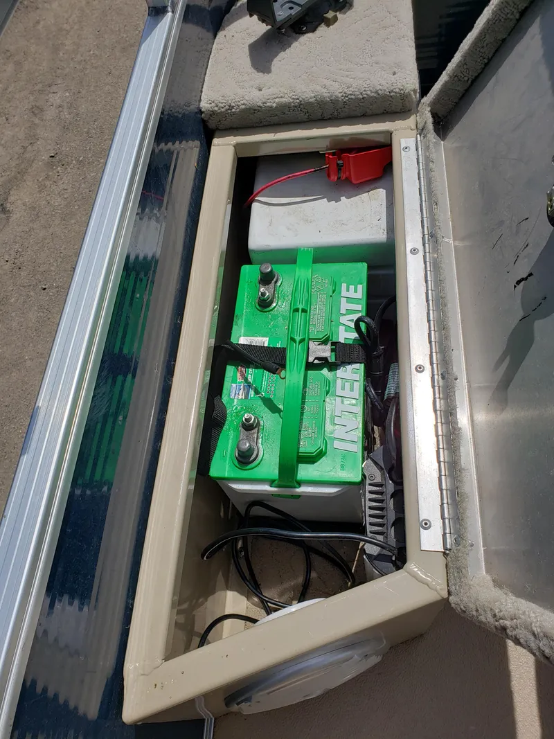 Slide: The Image of Battery compartment of a 2015 Lowe SF214 Sport Fish boat with green marine battery. - 10