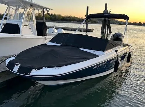 Slide: The Image of 2023 Sea Ray SPX 210 OB boat docked at sunset, covered and ready for adventure. - 2