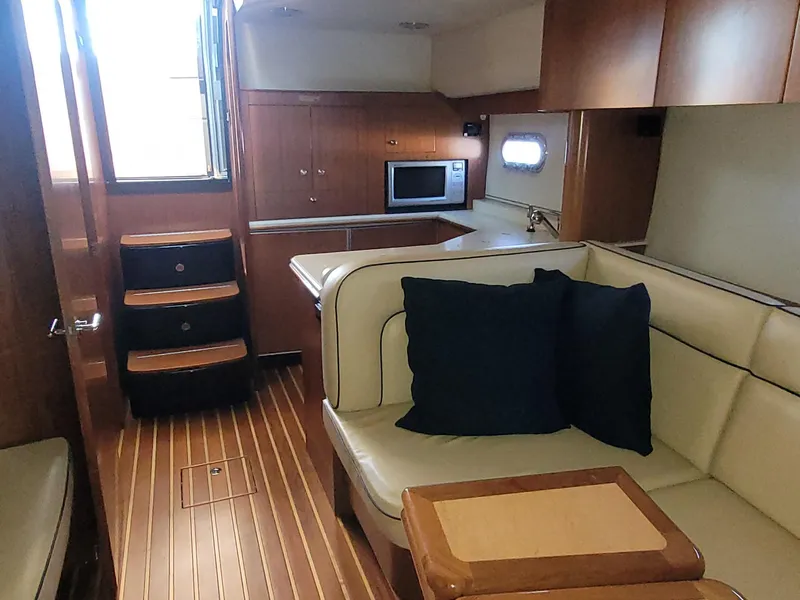 Slide: The Image of 2005 Tiara Yachts 4400 Sovran interior with kitchen, seating area, and wooden flooring. - 26
