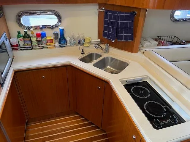 Slide: The Image of 2005 Tiara Yachts 4400 Sovran kitchen with dual sinks and electric stove. - 29