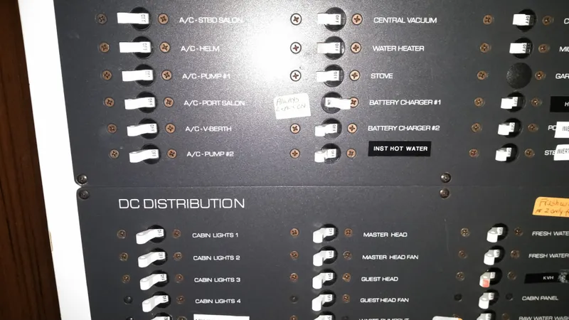 Slide: The Image of Electrical panel of a 2005 Tiara Yachts 4400 Sovran, showing AC and DC distribution switches. - 32