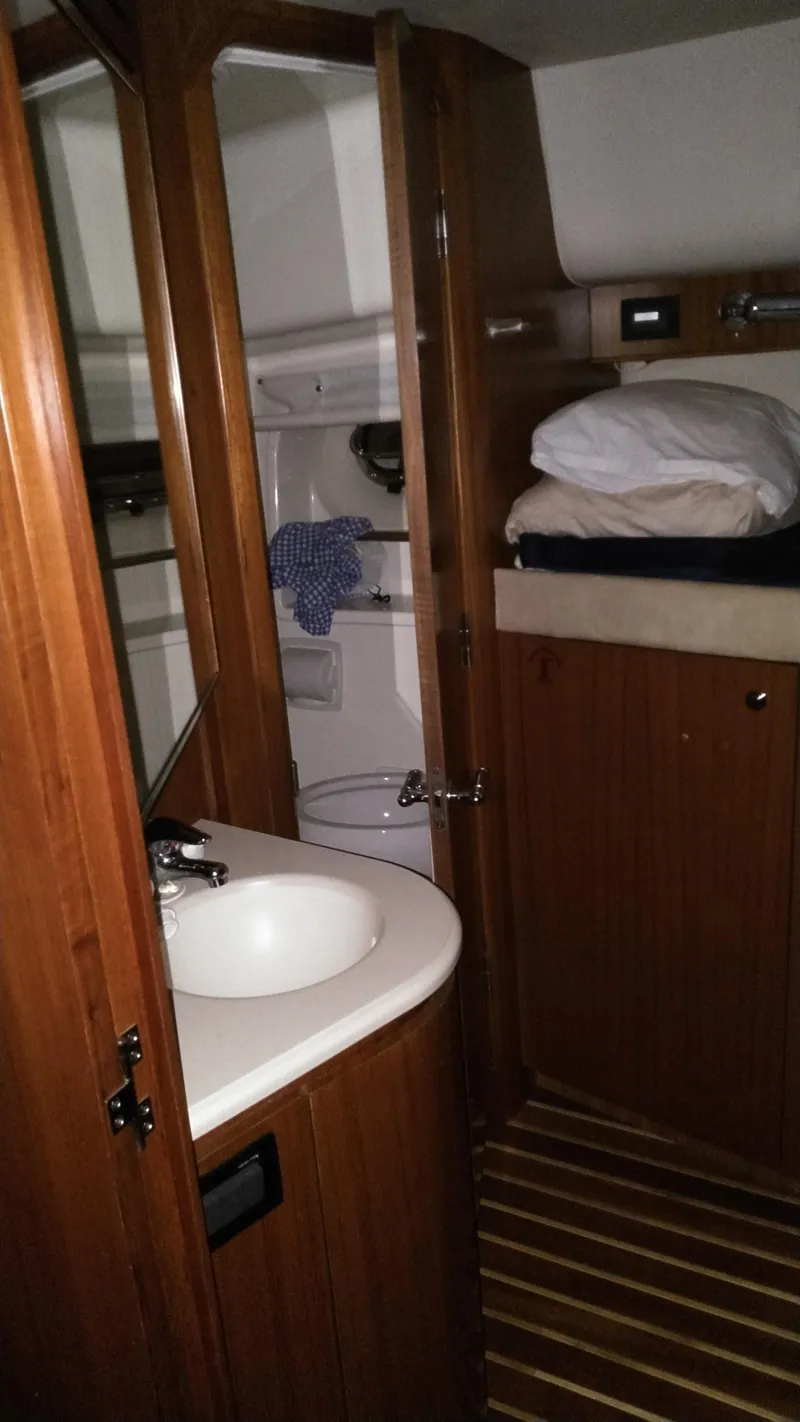 Slide: The Image of 2005 Tiara Yachts 4400 Sovran interior with wooden cabinetry and compact bathroom. - 33