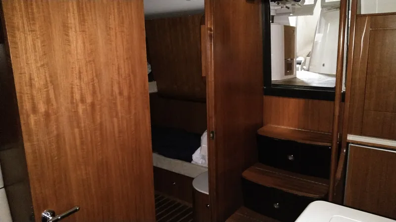 Slide: The Image of Interior of 2005 Tiara Yachts 4400 Sovran, featuring wooden cabinetry and compact design. - 35
