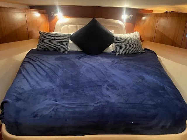 Slide: The Image of Luxurious cabin bed in 2005 Tiara Yachts 4400 Sovran with navy bedding and accent pillows. - 37