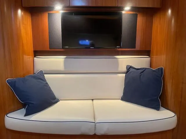 Slide: The Image of Interior of 2005 Tiara Yachts 4400 Sovran with white seating and blue pillows. - 44