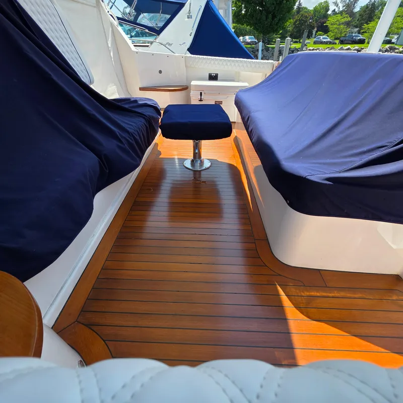 Slide: The Image of 2005 Tiara Yachts 4400 Sovran interior with wooden flooring and blue-covered seating. - 49