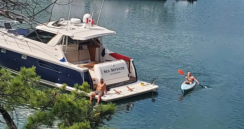 Slide: The Image of 2005 Tiara Yachts 4400 Sovran moored with kayaker nearby on calm water. - 7