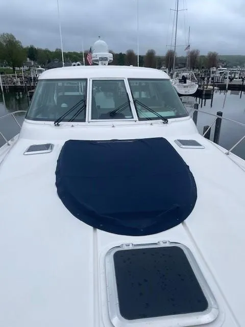 Slide: The Image of 2005 Tiara Yachts 4400 Sovran docked at a marina on a cloudy day. - 9