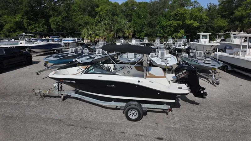 Slide: The Image of 2018 Sea Ray 190 Bow Rider boat on trailer, parked in marina lot. - 25