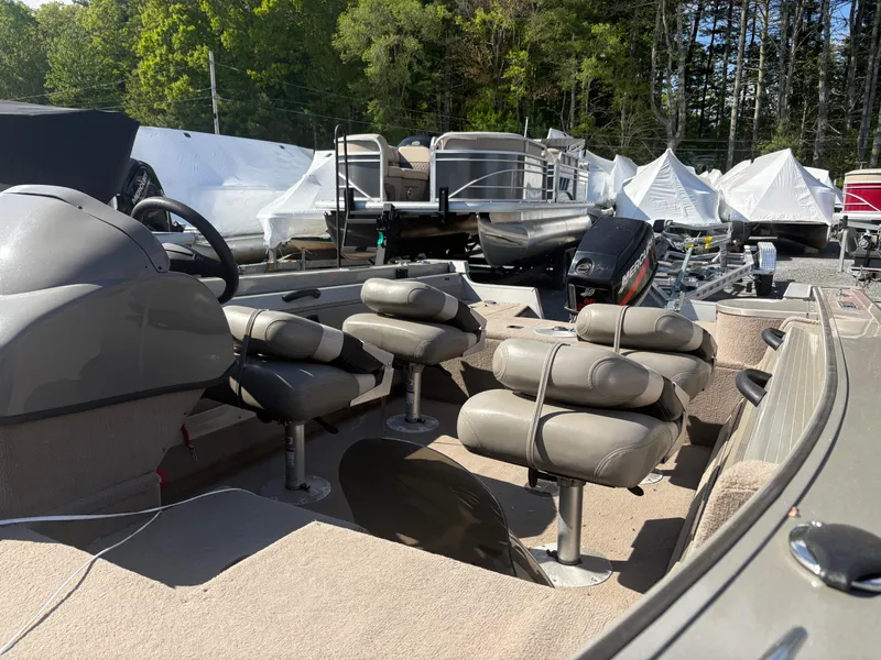 Slide: The Image of 2003 Tracker Targa 17 SC boat interior with seating and steering wheel, parked outdoors. - 8