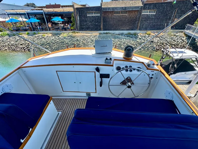 Slide: The Image of 1977 Grand Banks 42 Classic yacht helm with blue seating and wooden accents. - 10