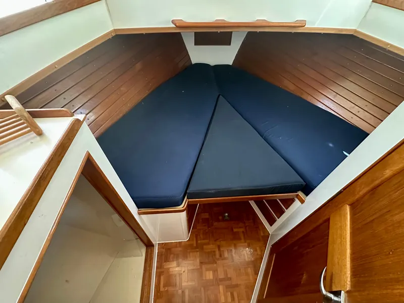 Slide: The Image of 1977 Grand Banks 42 Classic cabin with wooden interior and blue cushions. - 5