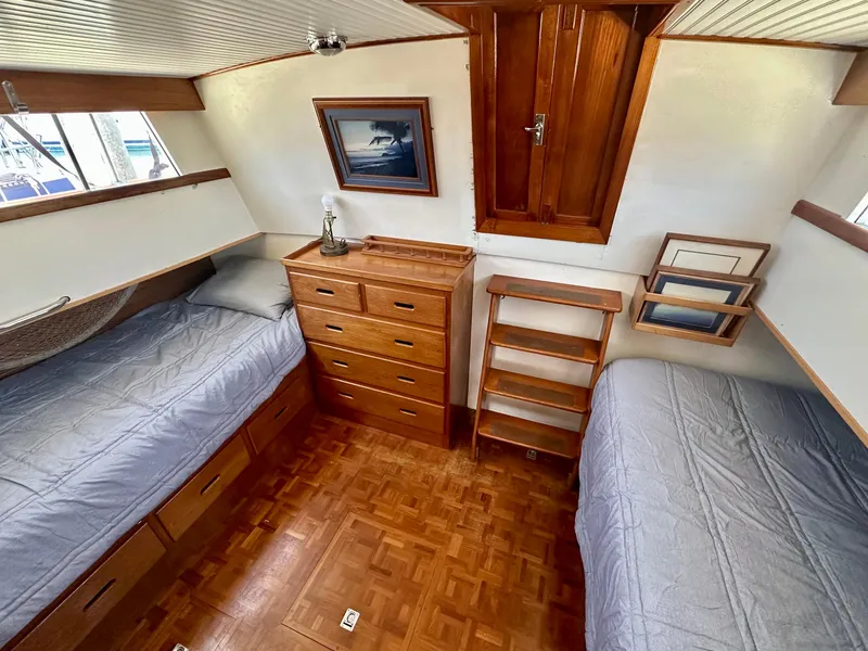Slide: The Image of 1977 Grand Banks 42 Classic cabin with twin beds, wooden drawers, and nautical decor. - 7