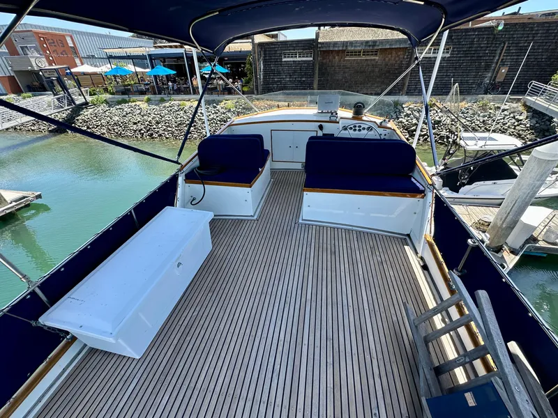Slide: The Image of 1977 Grand Banks 42 Classic yacht deck with seating and canopy at marina. - 9