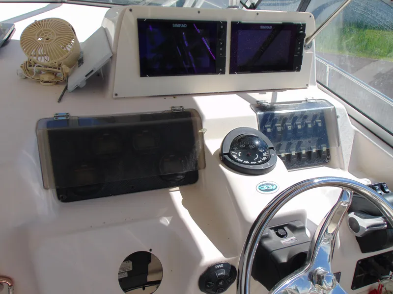 Slide: The Image of 2002 Grady-White 30 Marlin WA boat dashboard with steering wheel and navigation instruments. - 17