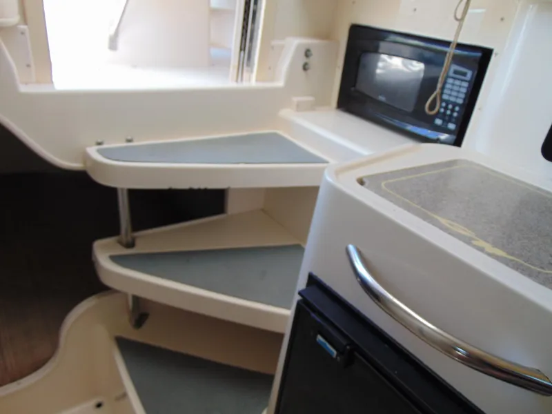 Slide: The Image of Interior of 2002 Grady-White 30 Marlin WA with stairs, microwave, and compact kitchen area. - 26