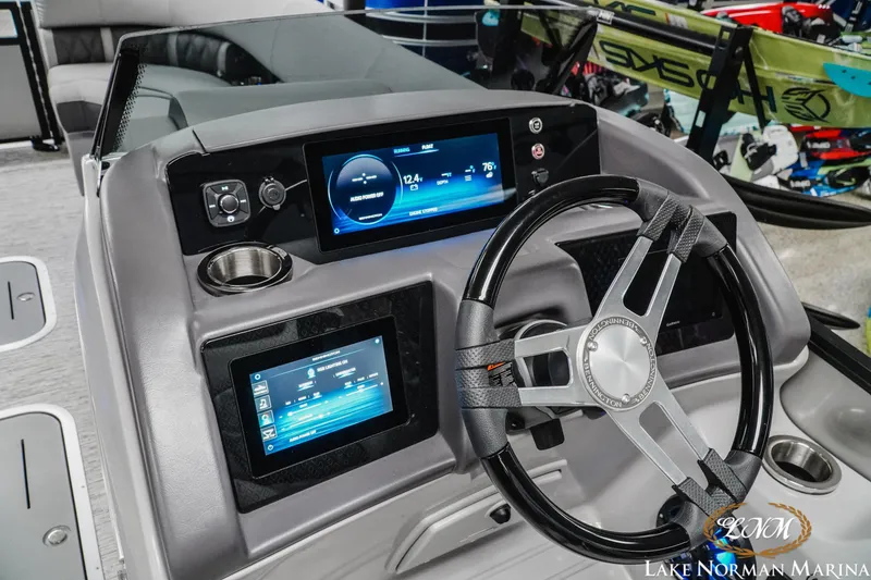 Slide: The Image of 2025 Bennington 24LXSFB boat dashboard with modern controls and steering wheel at Lake Norman Marina. - 11
