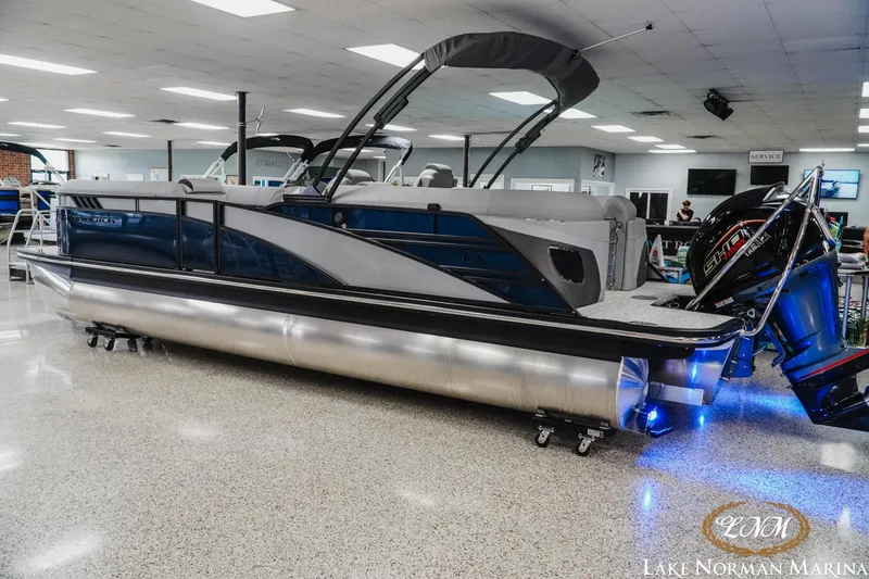 Slide: The Image of 2025 Bennington 24LXSFB pontoon boat displayed indoors with modern design and blue accents. - 3