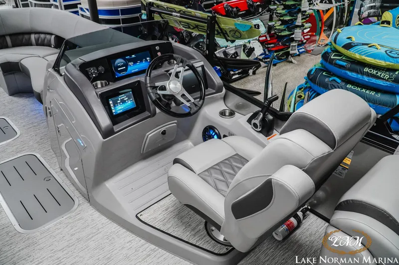 Slide: The Image of 2025 Bennington 24LXSFB boat interior with modern dashboard and seating at Lake Norman Marina. - 9