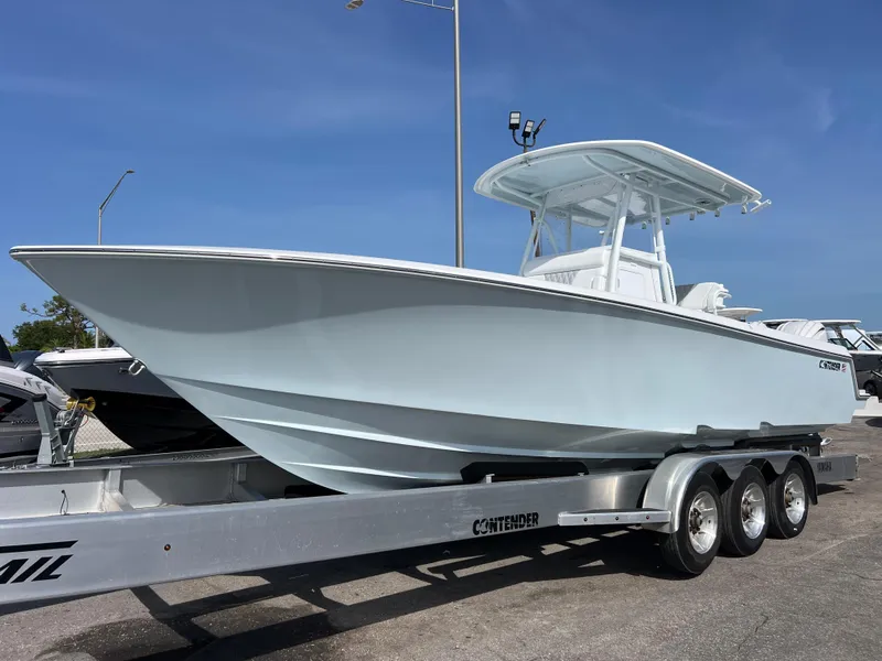 The Image of 2025 Contender 30 ST boat on a trailer, displayed outdoors under a clear blue sky. - 0