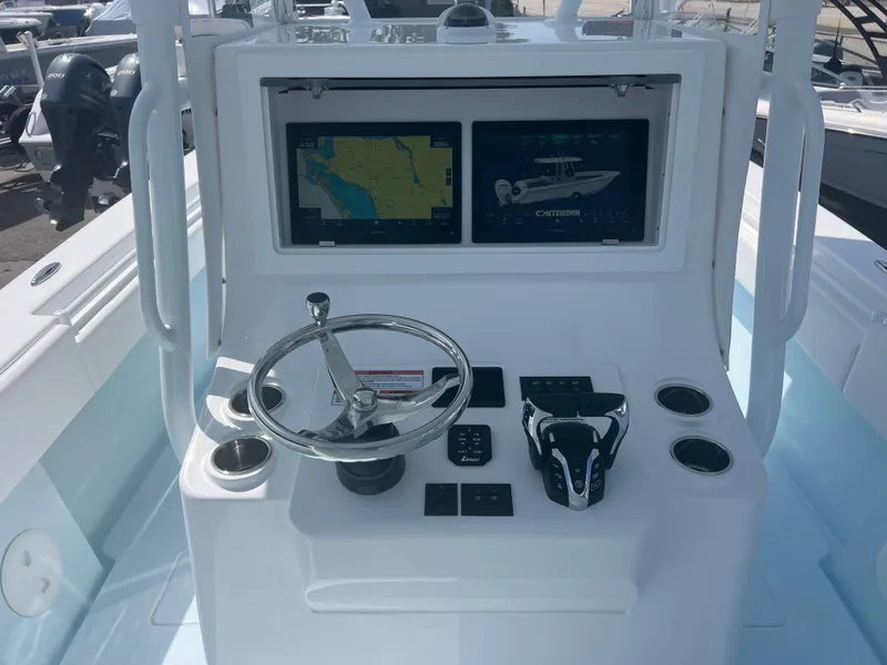 Slide: The Image of 2025 Contender 30 ST boat dashboard with navigation screens and steering wheel. - 11