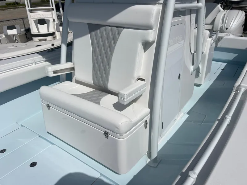 Slide: The Image of 2025 Contender 30 ST boat interior with white cushioned seating and storage. - 17