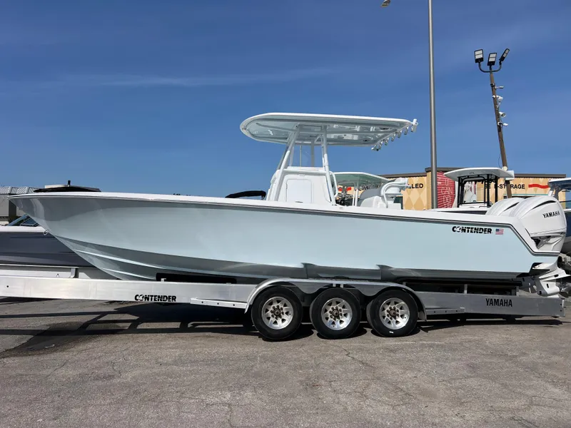 Slide: The Image of 2025 Contender 30 ST boat on trailer, side view, clear sky background. - 2