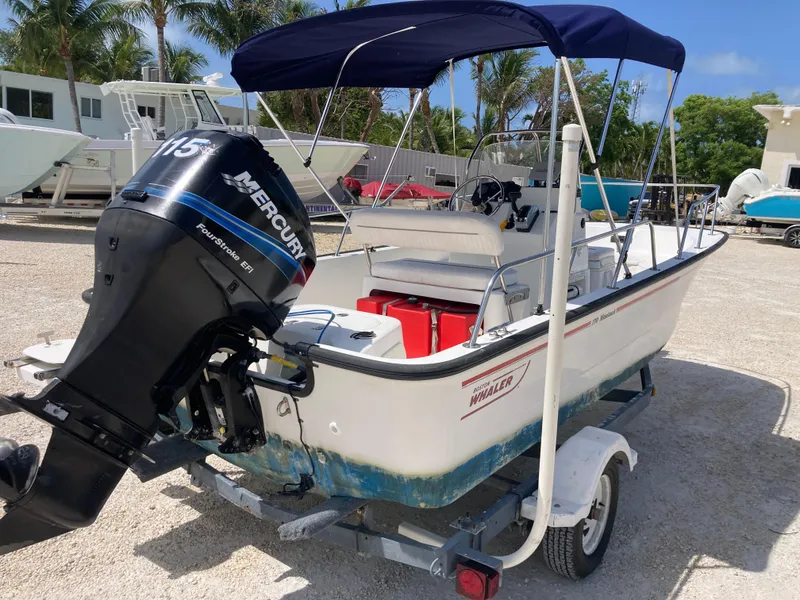 Slide: The Image of 2005 Boston Whaler 170 Montauk boat with Mercury engine on trailer, parked outdoors. - 3