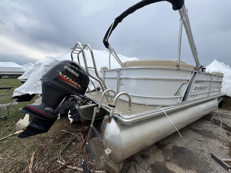 Slide: The Image of 2019 Starcraft EX 20 R pontoon boat with Yamaha outboard motor, parked on grass. - 11