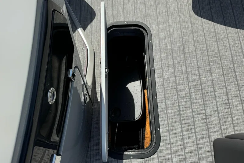 Slide: The Image of Open storage compartment on 2020 Manitou Oasis SR boat with textured flooring. - 14