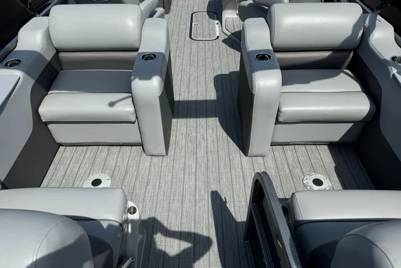 Slide: The Image of 2020 Manitou Oasis SR boat interior with gray seating and textured flooring. - 2