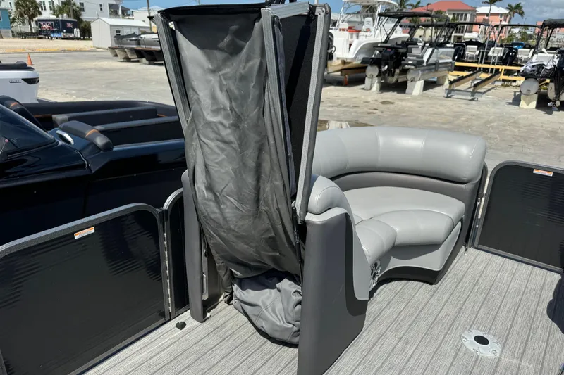 Slide: The Image of 2020 Manitou Oasis SR pontoon boat with gray seating and privacy curtain on deck. - 8